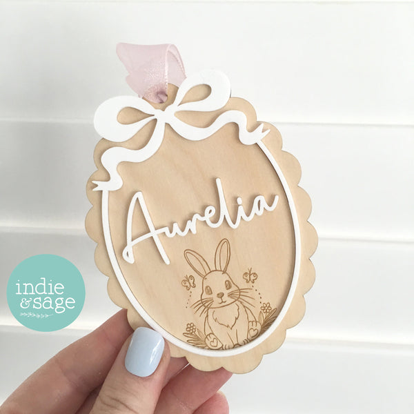 Personalised Easter basket tag featuring a bunny with butterflies and white acrylic bow border with a scalloped edge 

#easter2026 #easterdecor #easterbaskettag #eastergifts #easterbagtag #easterbasketnametag #eastergift #eastergiftforgrandchildren