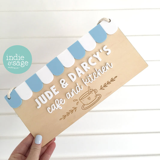 Personalised wooden café and kitchen sign featuring raised acrylic details in your chosen colours. The perfect gift for any budding chef or kid who loves some imaginative play.