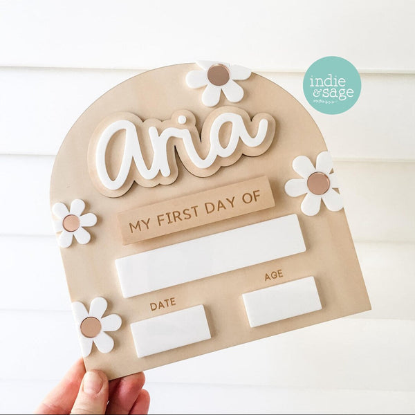 “Mini ‘First Day of School’ board in white and rose gold floral design. Personalised with child’s name and back-to-school questions on a white acrylic surface. Made from 3mm plywood with white acrylic top, Velcro dots for interchangeable names or ‘first day’ and ‘last day’ sections. Measures approximately 200x250mm. Reusable with chalk or whiteboard markers. Unique wood grain patterns visible. Handmade in Adelaide Hills by Indie & Sage.”

