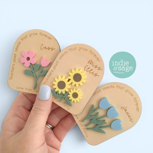 Personalised teacher flower magnet featuring custom teacher and student names with layered acrylic flowers and the message "Teachers plant seeds that grow forever"