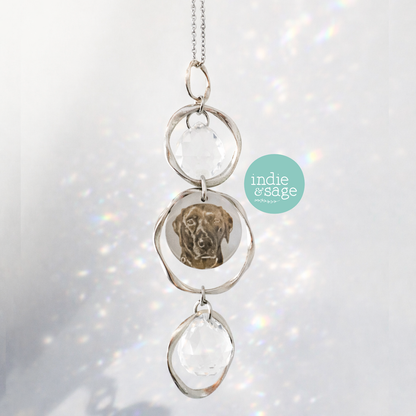 Personalised pet memorial suncatcher with engraved dog portrait catching rainbow light